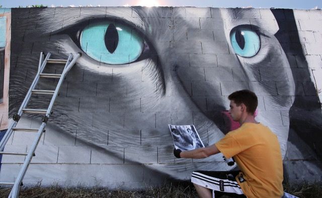 Peio García / ICAL Un grupo de grafiteros pinta el muro de la Protectora de Animales de León