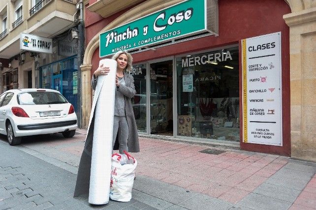 La propietaria de la mercería Pincha y Cose de León, Sonia Llamazares, recibe materiales de voluntarios para fabricar mascarillas y batas de protección. / Campillo / ICAL